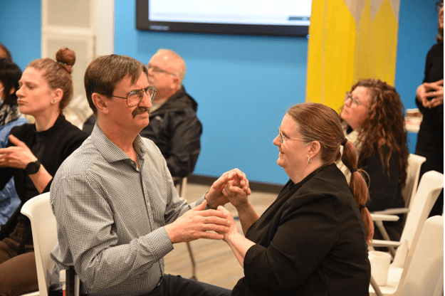 Access is being provided by tactile sign language during an event at Wavefront Centre for Communication Accessibility.